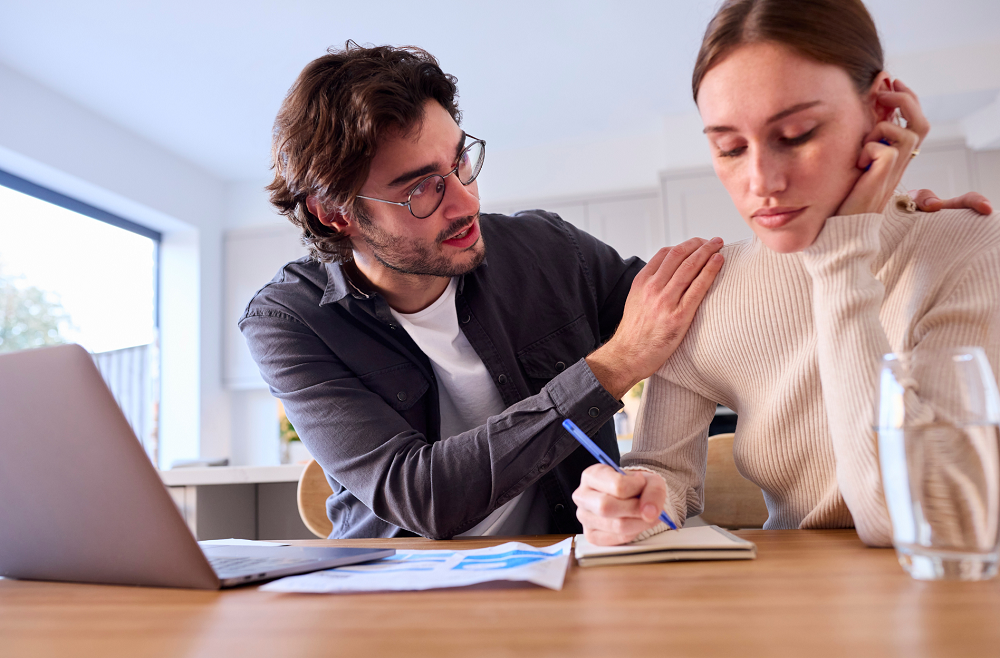 Worried couple at home looking at laptop